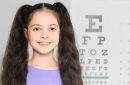Portrait of cute little girl visiting children's doctor, space for text. Eye examination